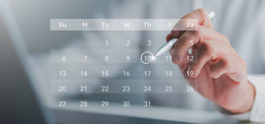 Hand mit elektronischem Stift wählt Termin in Kalender aus