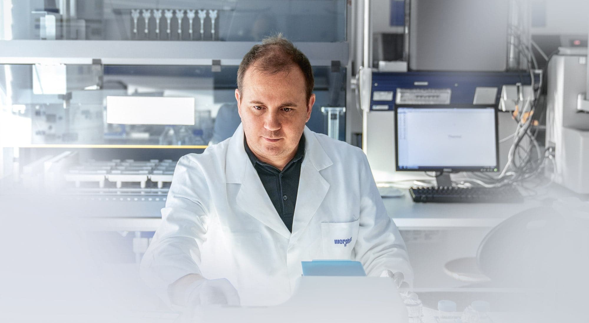 Labor MorphoSys - Mann in Laborkittel am Tisch